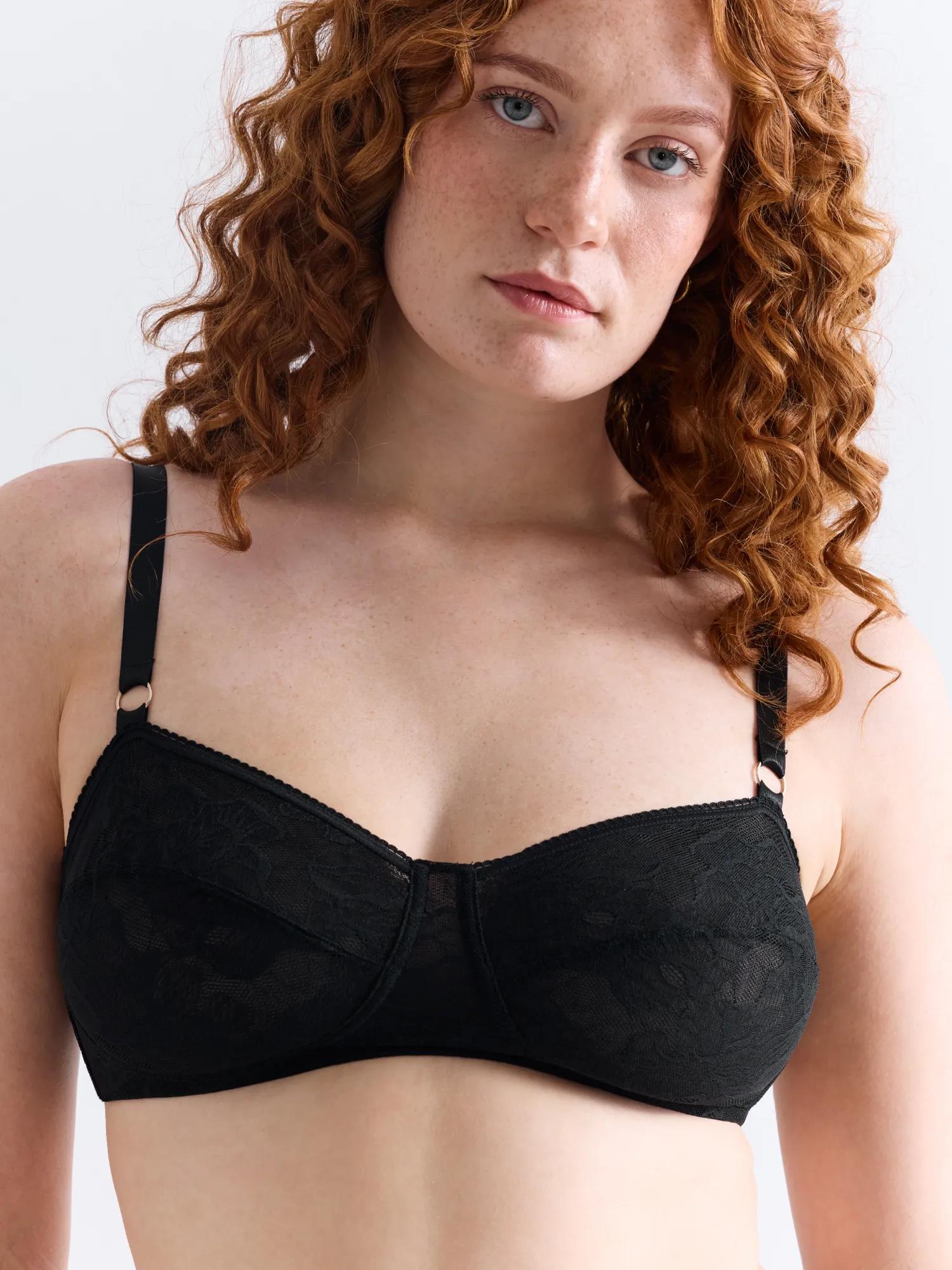 Frau im Oberkörper-Porträt trägt einen schwarzen bügellosen Spitzen-BH aus der Sleek-Lace-Kollektion von erlich textil